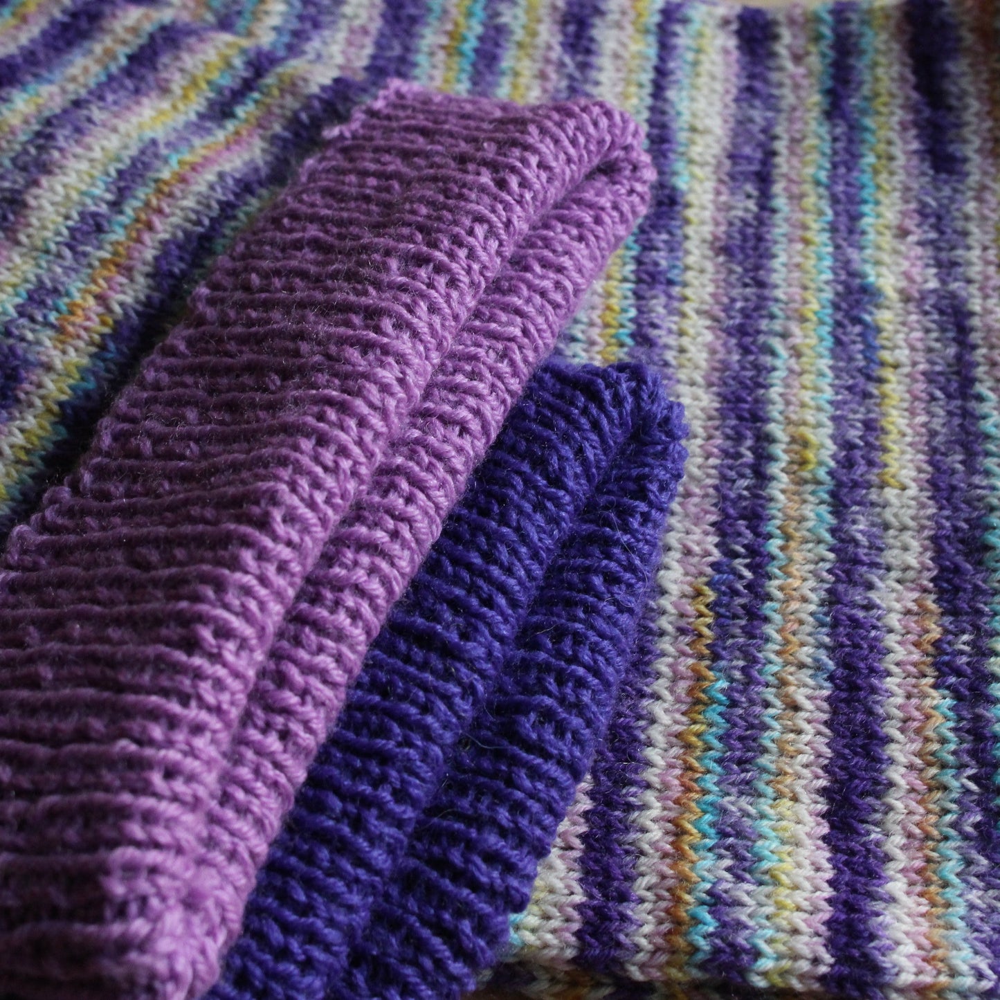 Rokām adīta cepuršalle lillā toņos ar strīpām (RECE 63)