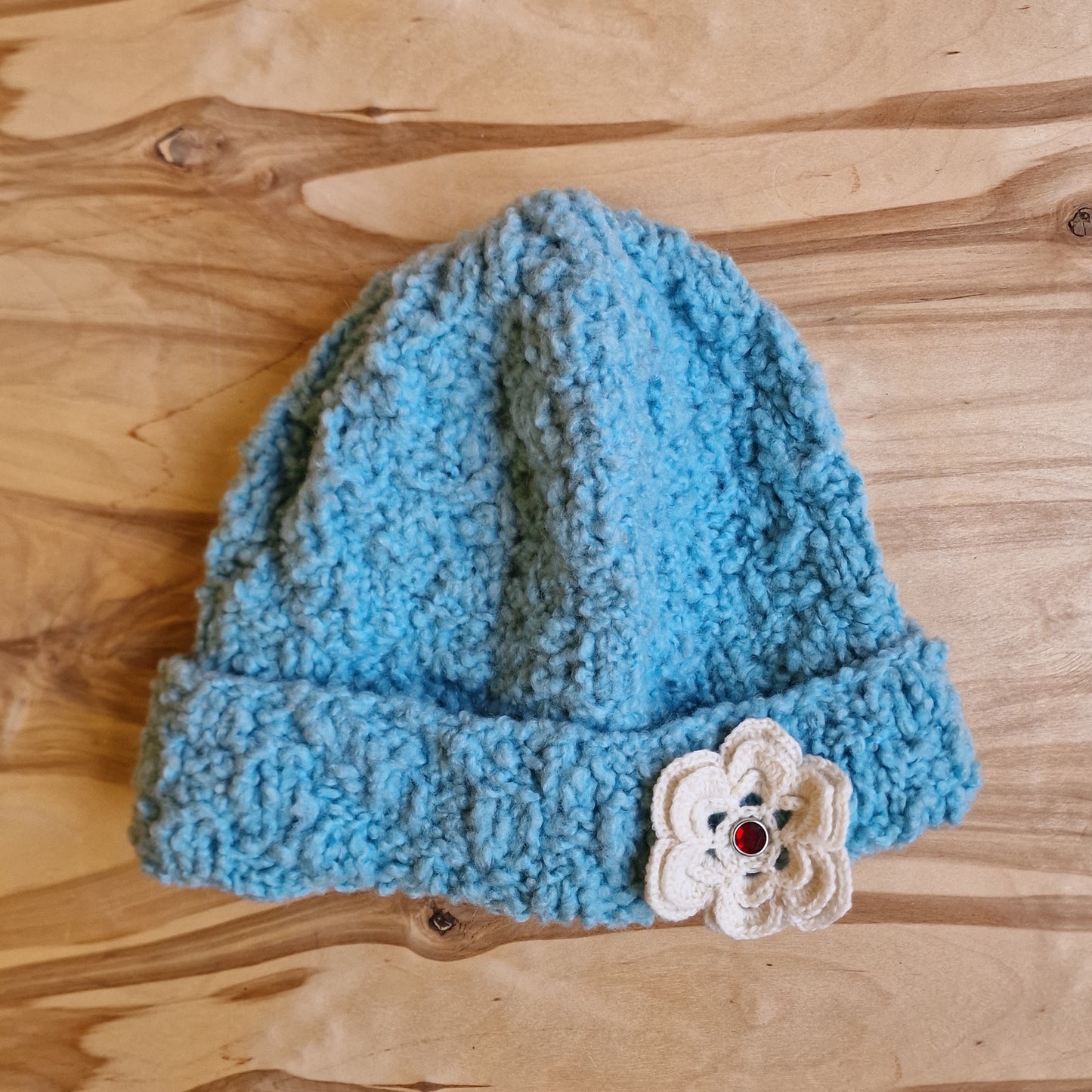 Rokām adīta gaiši zila cepure ar gaišu ziedu (DZTO 69) - www.tiptip.lv