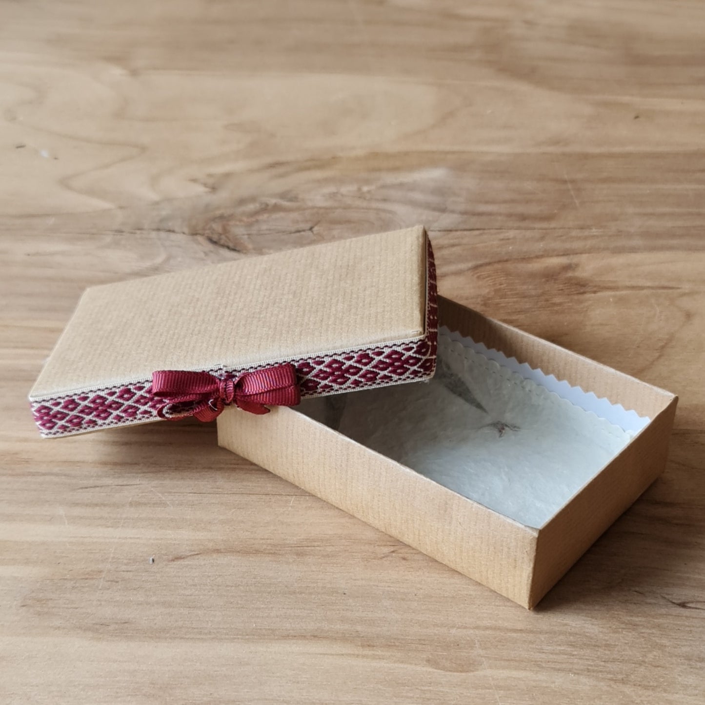 Dāvanu kārbiņa (iekšējie izmēri 11.8 x 7.8 cm) brūnā krāsā ar tautiskas joslas lentu ap vāka malu un gaišu iekšpusi (APU2) - www.tiptip.lv