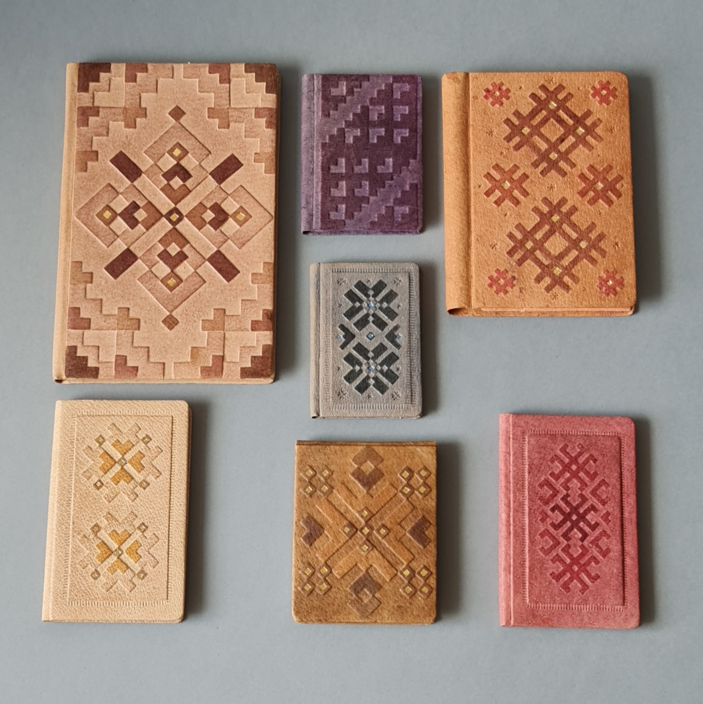 Rūtiņu bloknots ādas ievākojumā. Zilpelēkā krāsā ar dekoratīvu iespiedumu. 7 x 10 x 1 cm (MAPL 3) - www.tiptip.lv