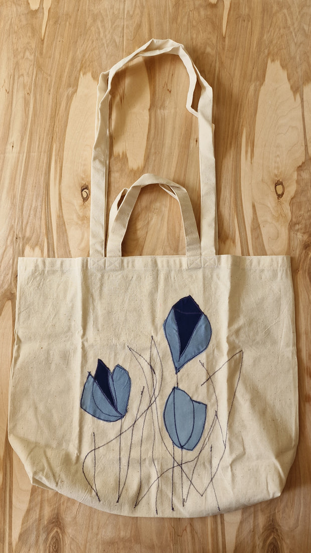 Auduma iepirkumu maisiņš ar uzšūtiem ziliem ziediem (LĪLU 10)