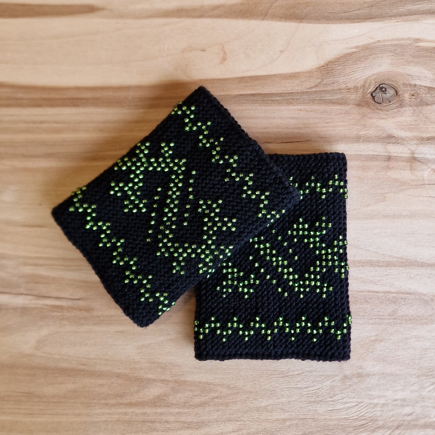 Black merino wool muffs/pulse warmers with light green grass-snake insignia (ANLA 18)