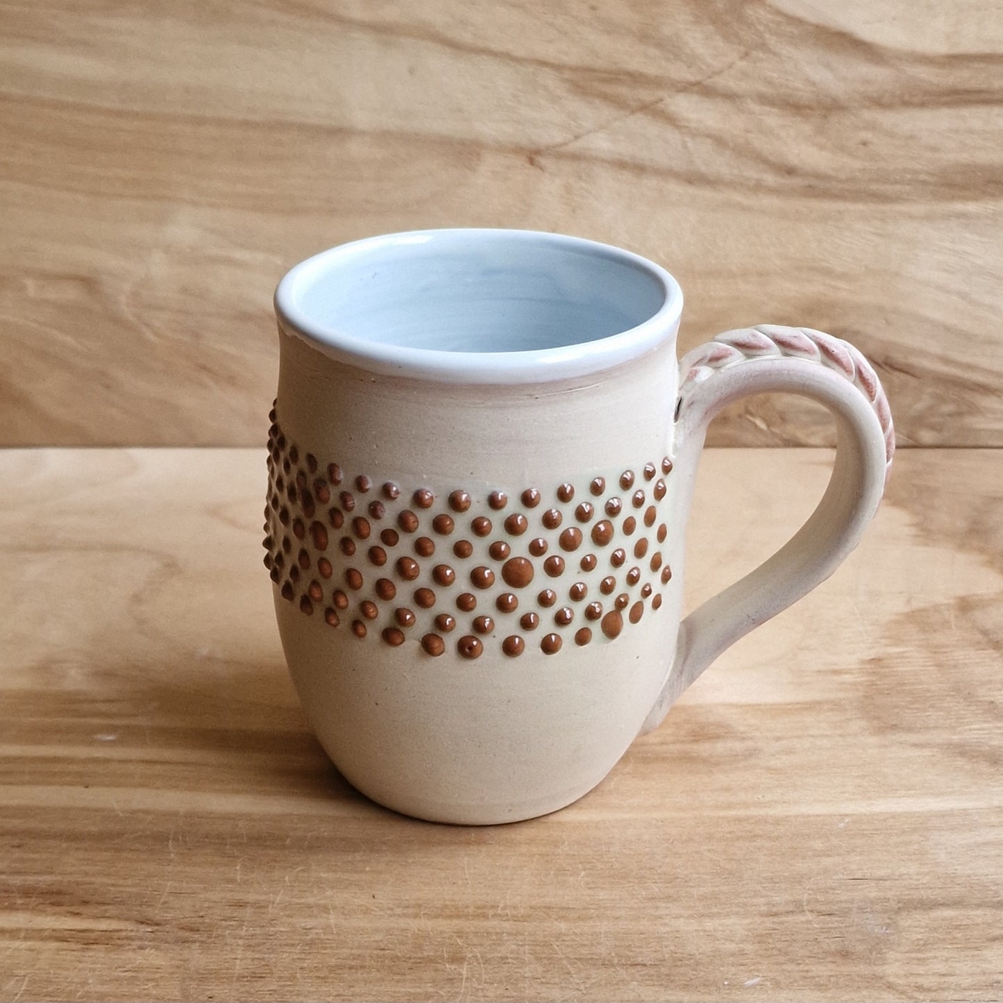 Light colored clay mug with illustrations (MASP 77)