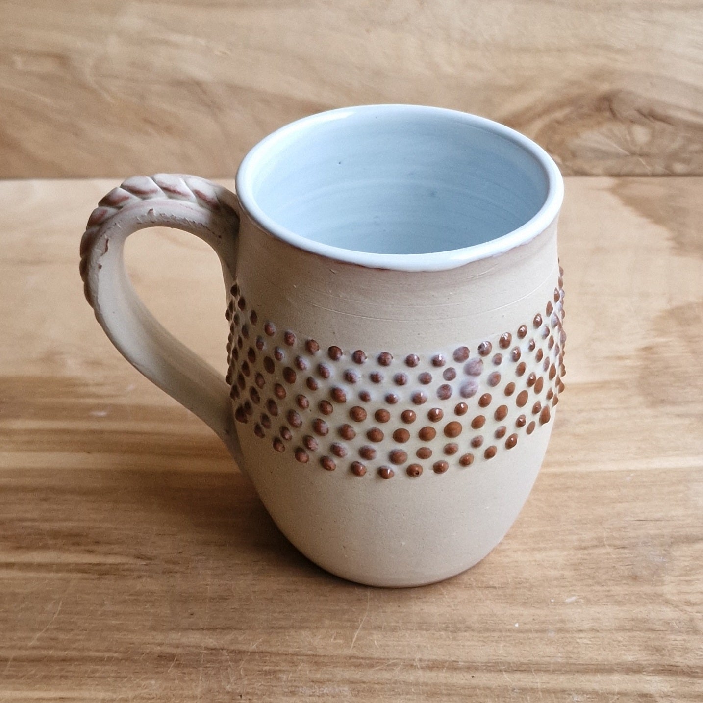 Light colored clay mug with illustrations (MASP 77)