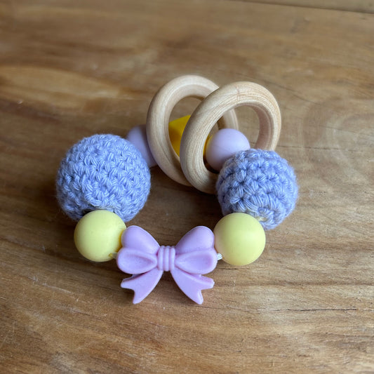 Tamborēts grabulītis lillā krāsā ar rozā silikona banti (AIPU 140)