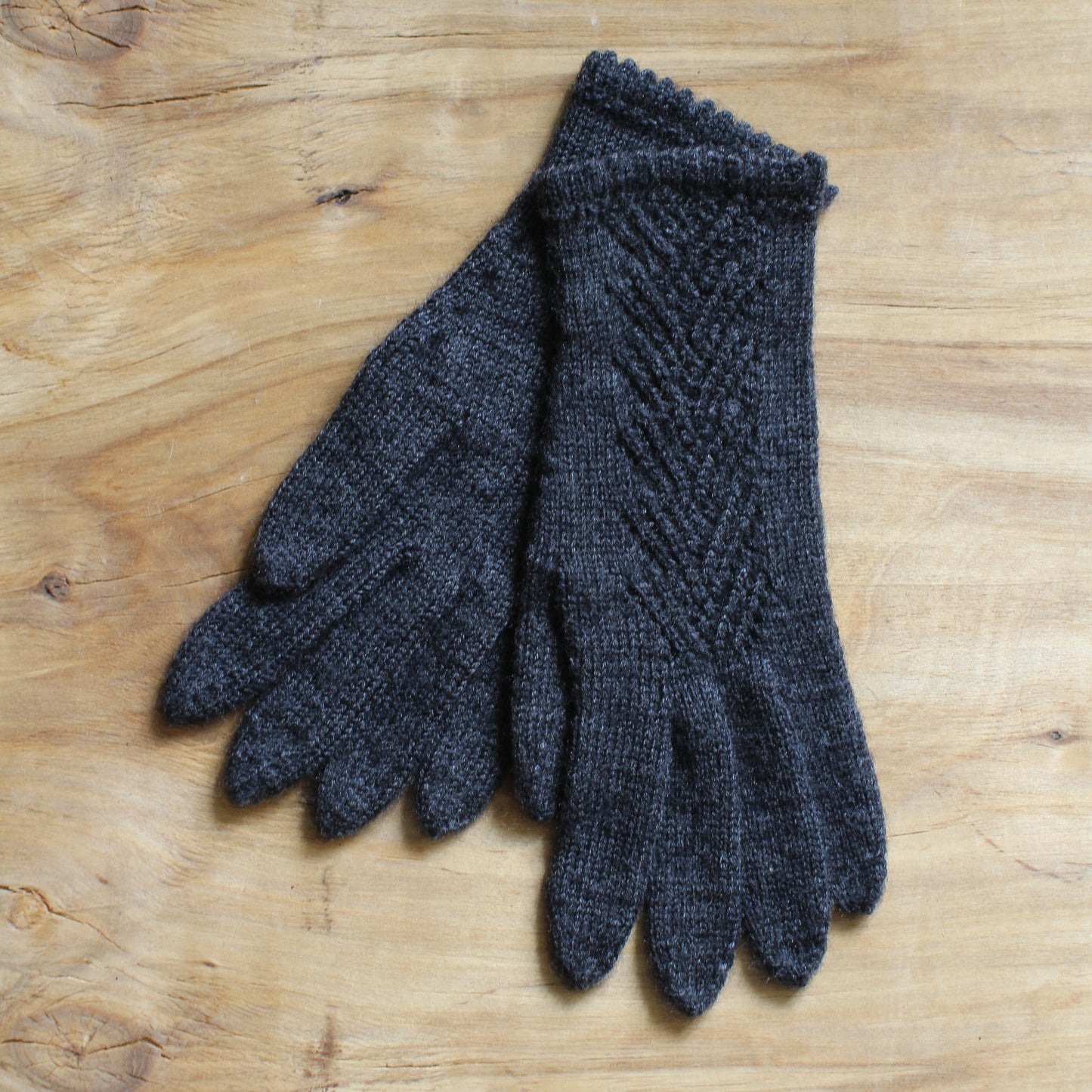 Rokām adīti tumši pelēki pirkstaiņi ar mežģīņu skujiņas rakstu plaukstas virspusē (INVA 36)