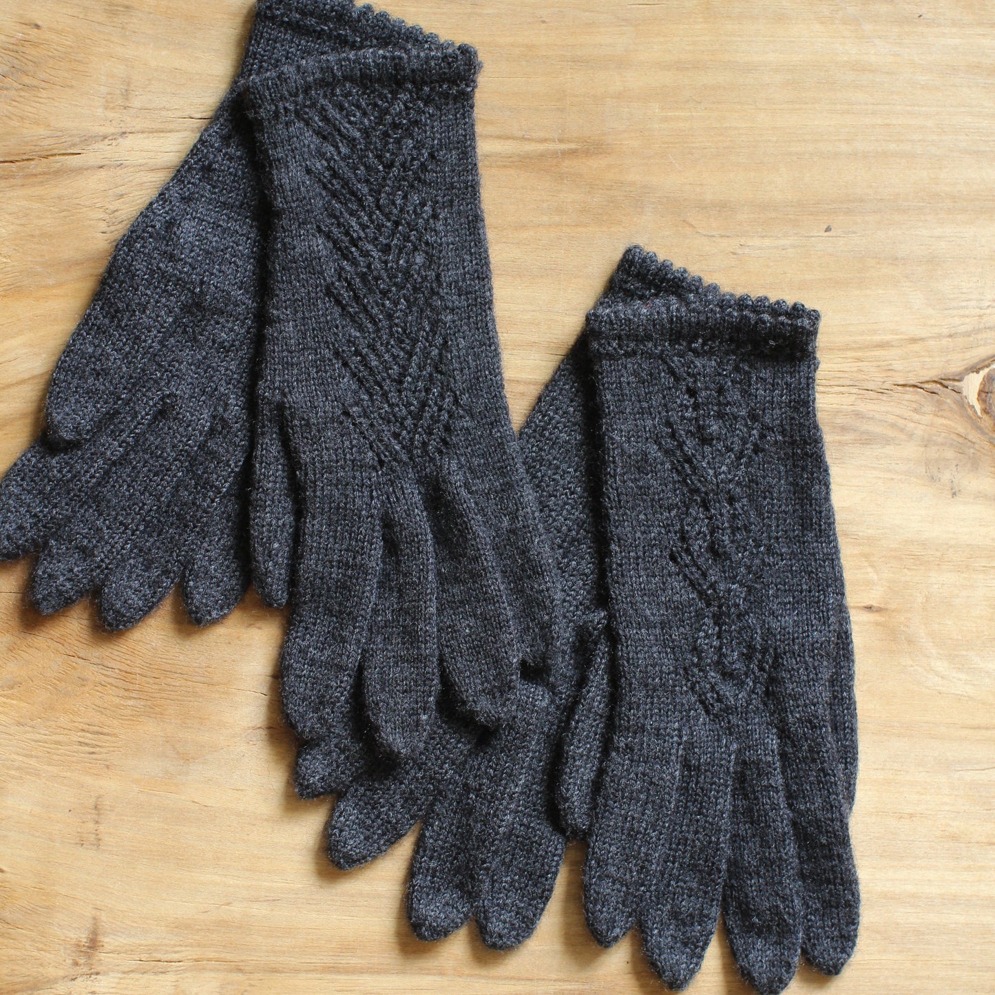 Rokām adīti tumši pelēki pirkstaiņi ar mežģīņu skujiņas rakstu plaukstas virspusē (INVA 36)