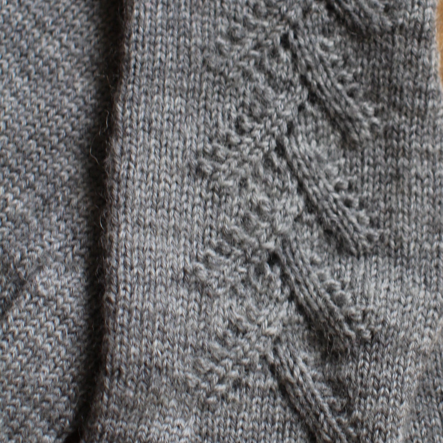 Rokām adīti gaiši pelēki pirkstaiņi ar mežģīņu skujiņas rakstu plaukstas virspusē (INVA 42)