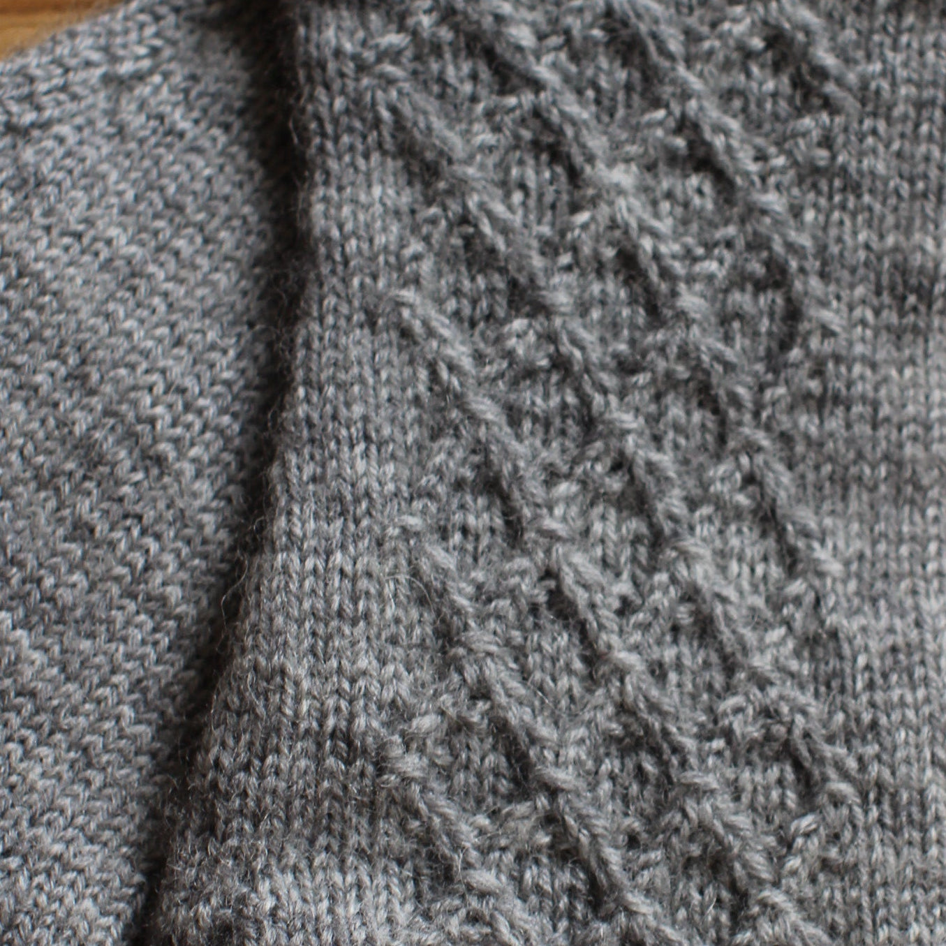 Rokām adīti gaiši pelēki pirkstaiņi ar lielāku rombiņu rakstu plaukstas virspusē (INVA 44)