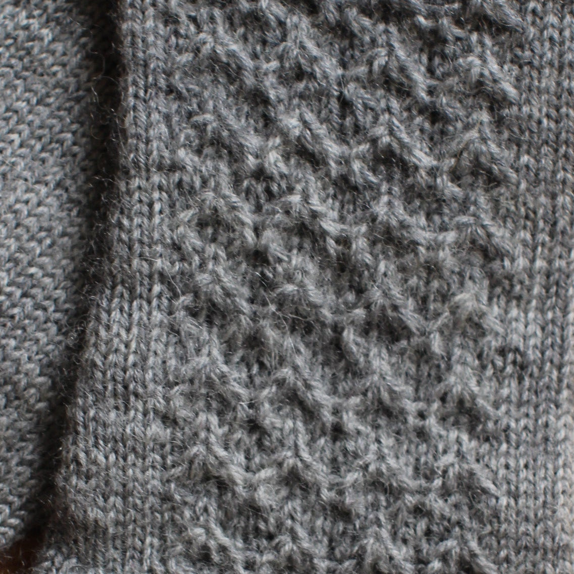 Rokām adīti gaiši pelēki pirkstaiņi ar rombiņu rakstu plaukstas virspusē (INVA 43)