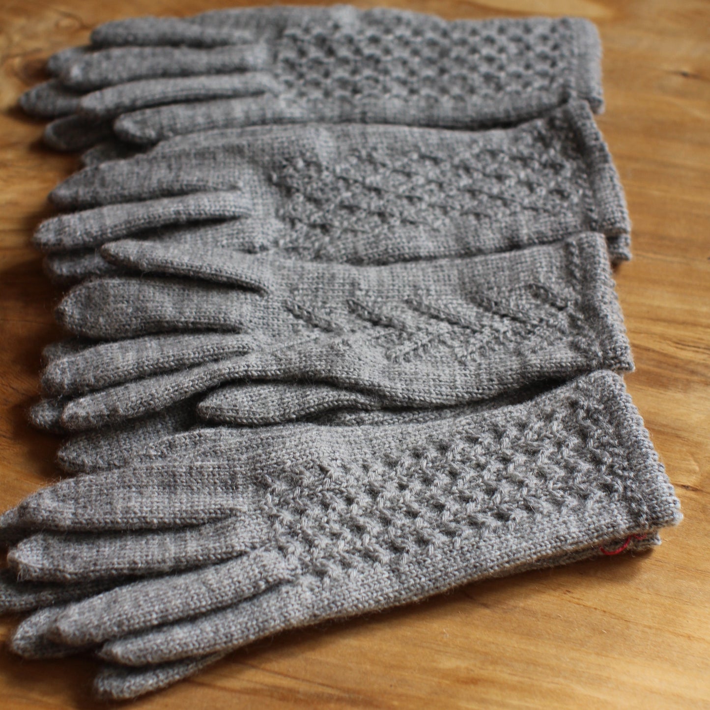 Rokām adīti gaiši pelēki pirkstaiņi ar rombiņu rakstu plaukstas virspusē (INVA 43)