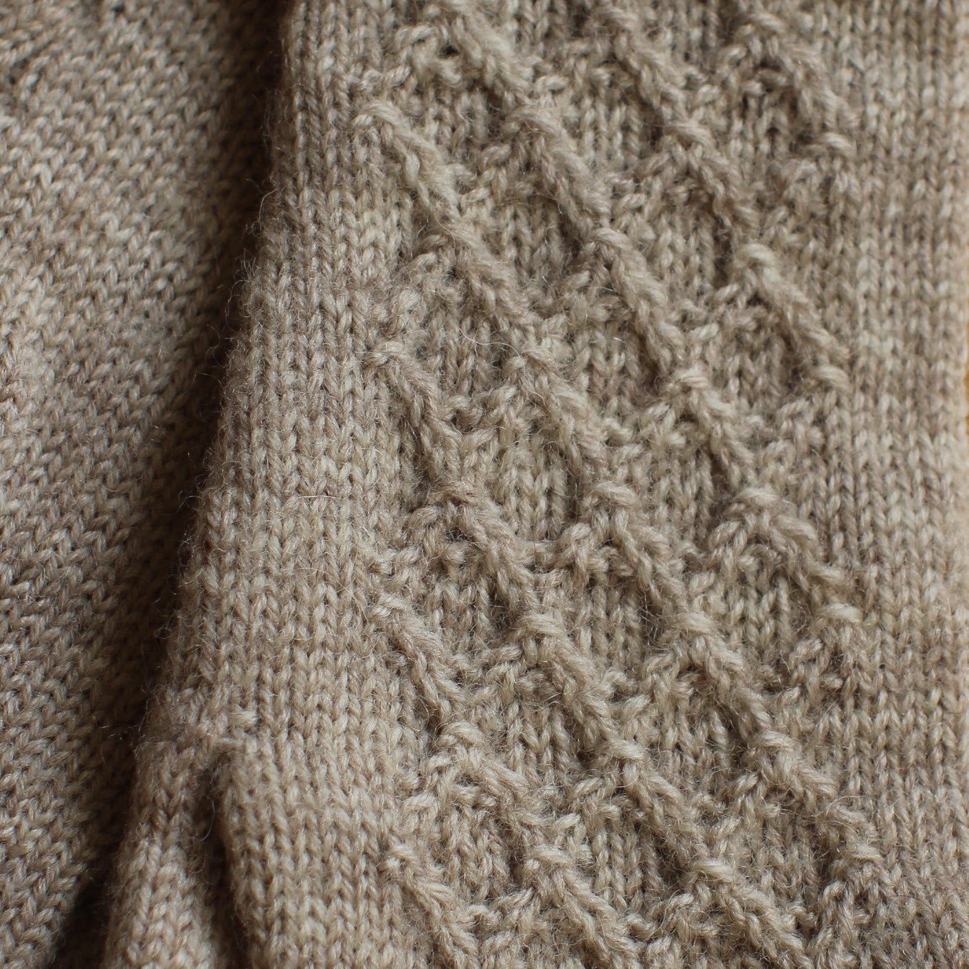 Rokām adīti smilškrāsas pirkstaiņi ar lielāku rombiņu rakstu plaukstas virspusē (INVA 46)