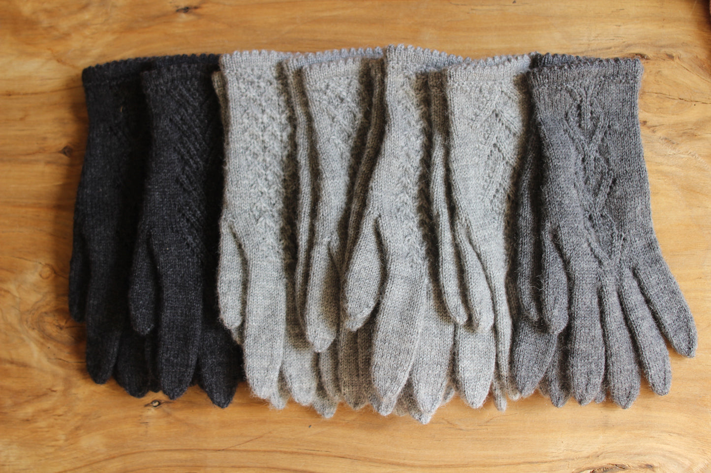 Rokām adīti tumši pelēki pirkstaiņi ar mežģīņu skujiņas rakstu plaukstas virspusē (INVA 36)