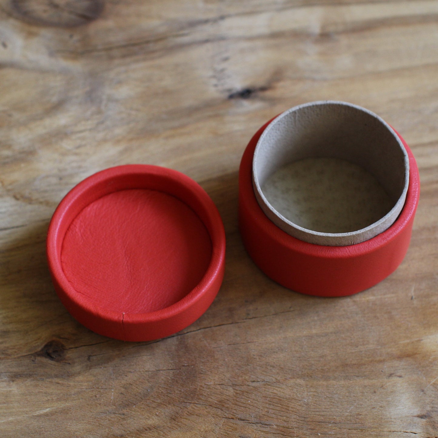 Sarkana, apaļa dekoratīva ādas kārbiņa (S) ar zilgani marmorētu vāku (RARA 252)