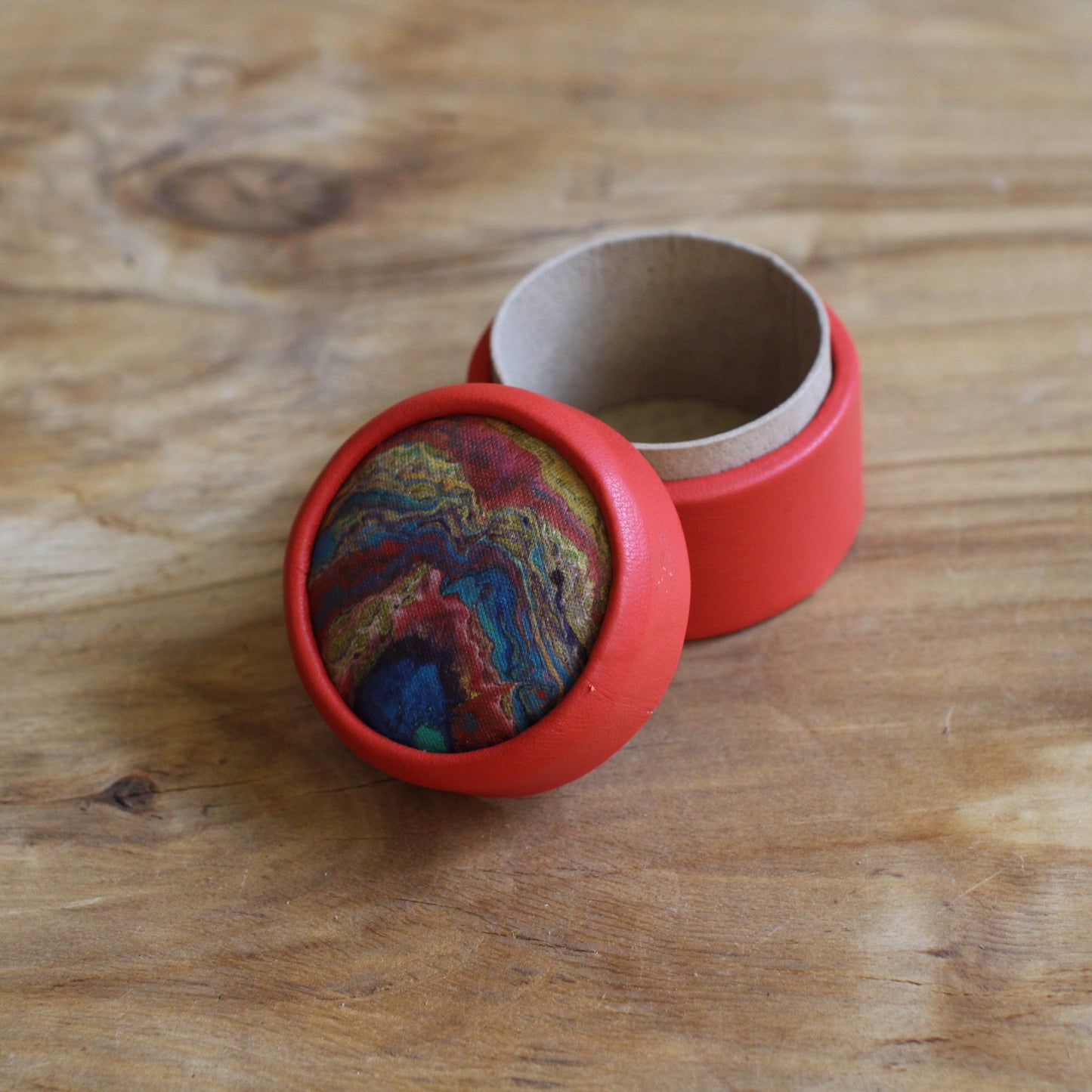 Sarkana, apaļa dekoratīva ādas kārbiņa (S) ar zilgani marmorētu vāku (RARA 252)