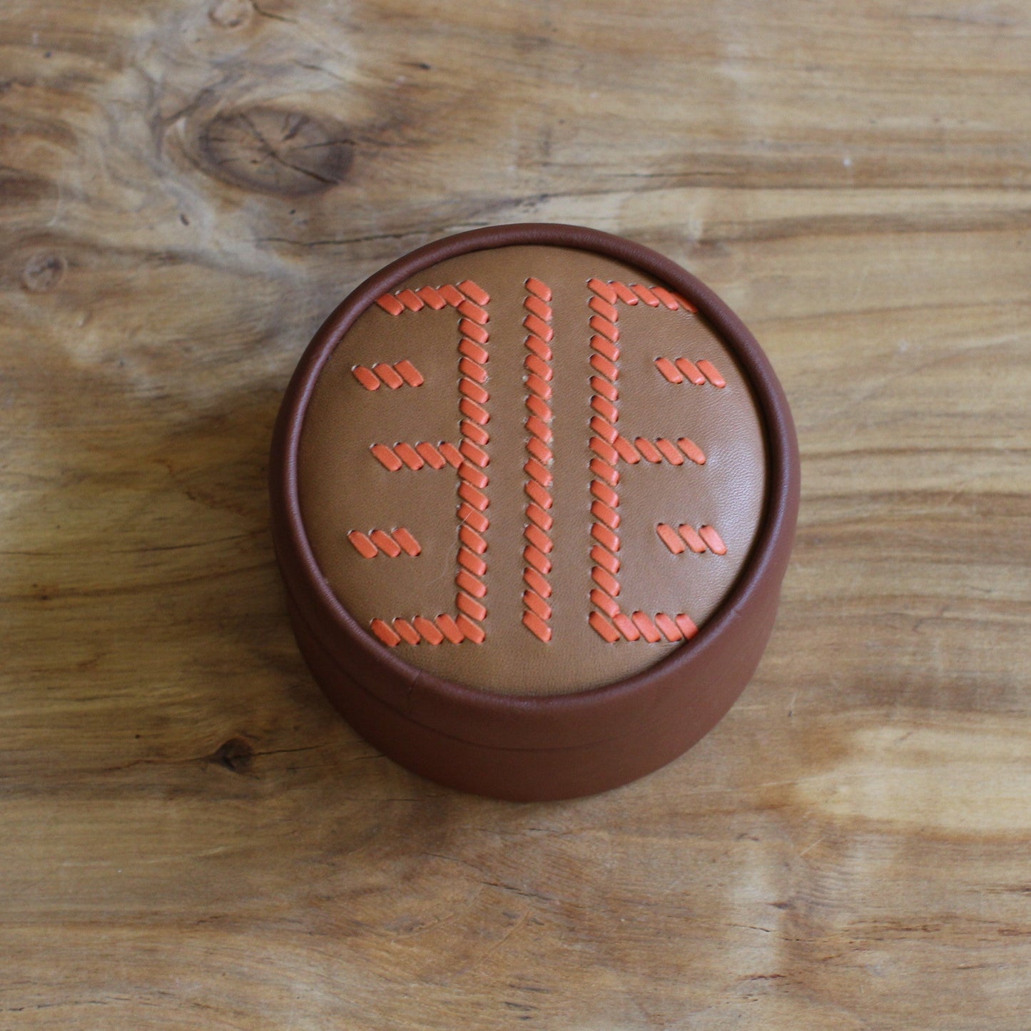 Brūna, apaļa dekoratīva ādas kārbiņa latviešu etnogrāfisko zīmju rakstu  (RARA 256)