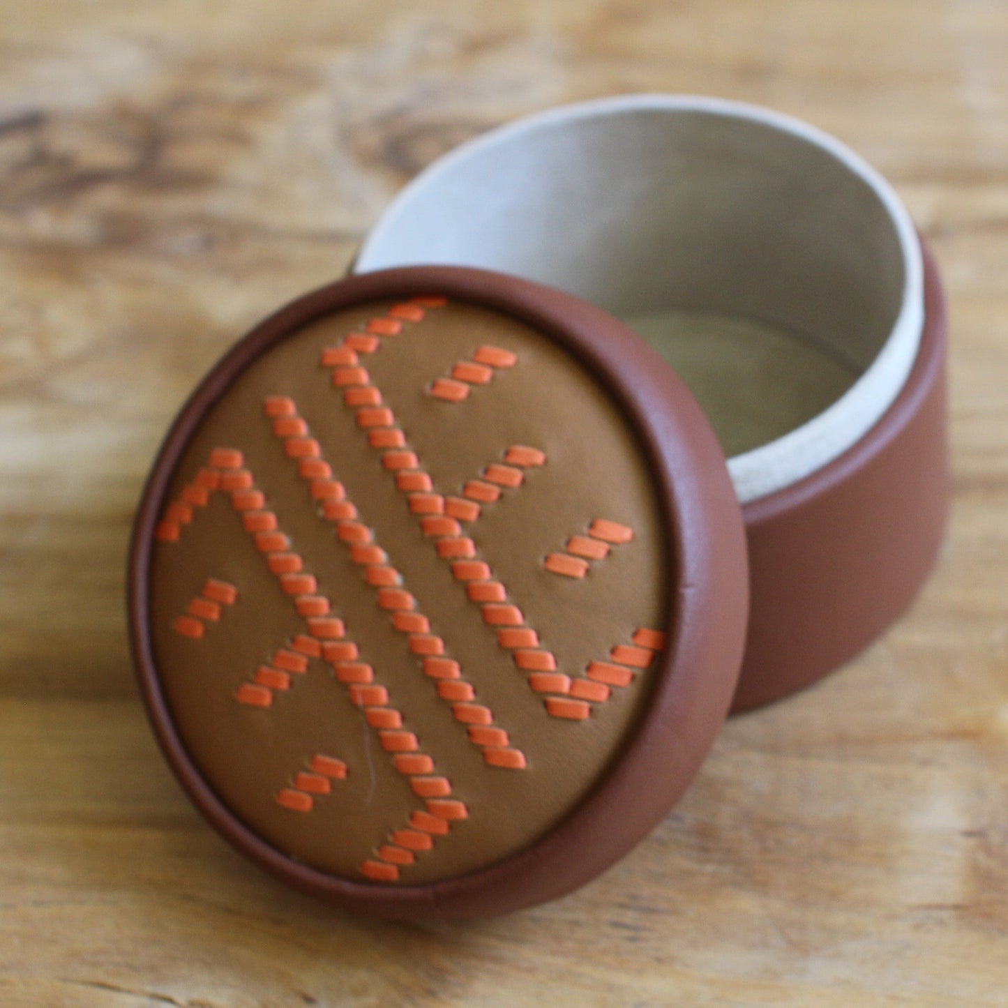 Brūna, apaļa dekoratīva ādas kārbiņa latviešu etnogrāfisko zīmju rakstu  (RARA 256)