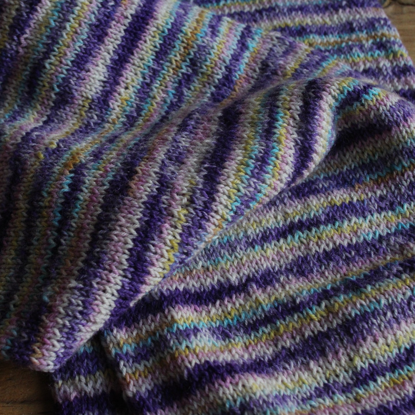 Rokām adīta cepuršalle lillā toņos ar strīpām (RECE 63)