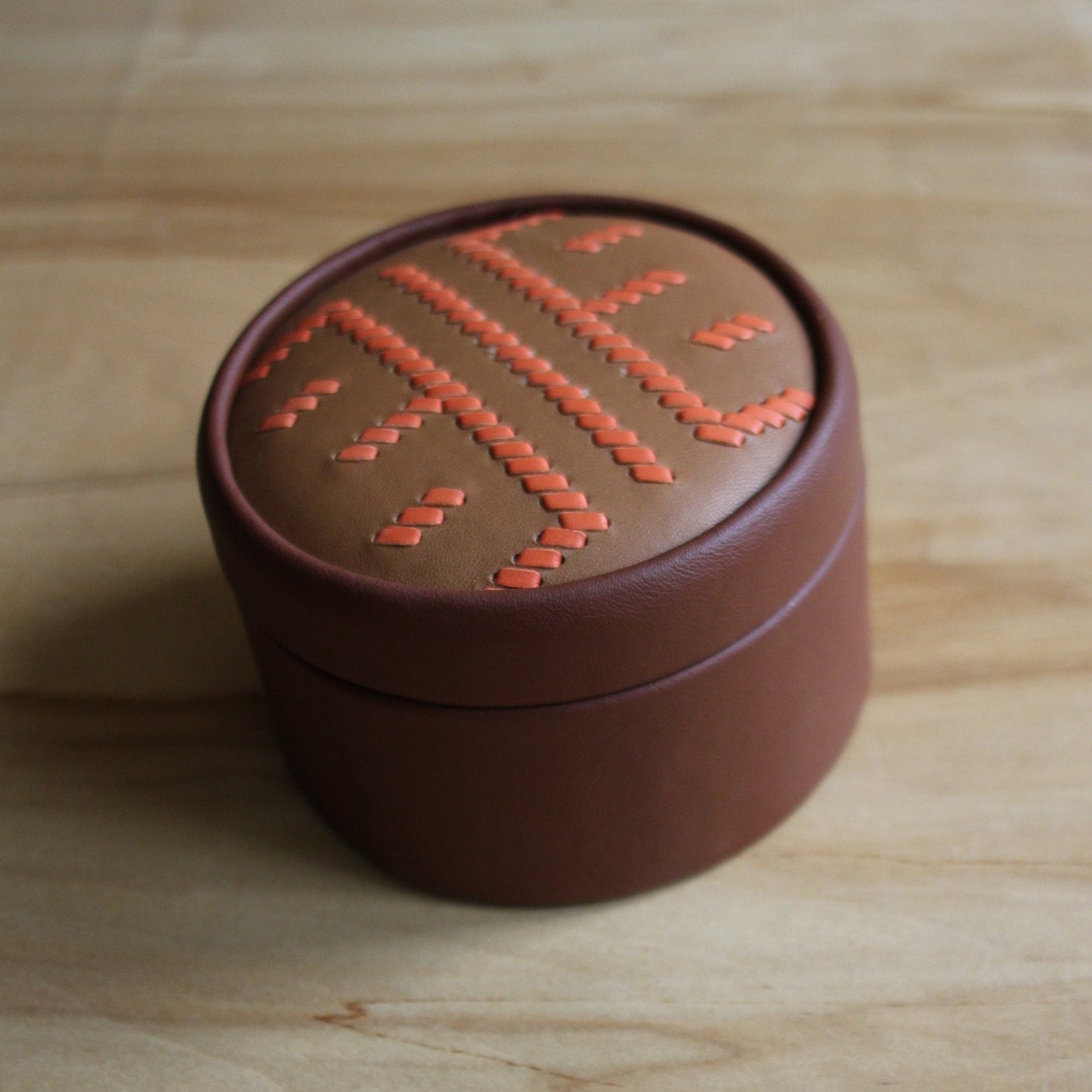 Brūna, apaļa dekoratīva ādas kārbiņa latviešu etnogrāfisko zīmju rakstu  (RARA 256)