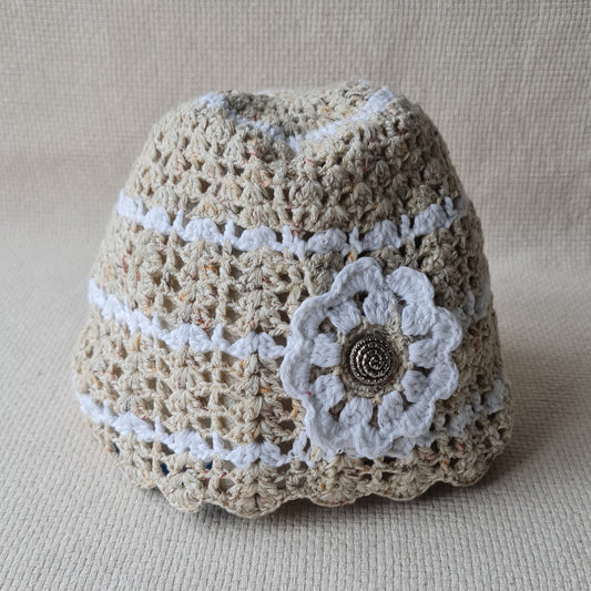 Balti bēšīga tamborēta cepure ar dekoratīvu baltu ziedu