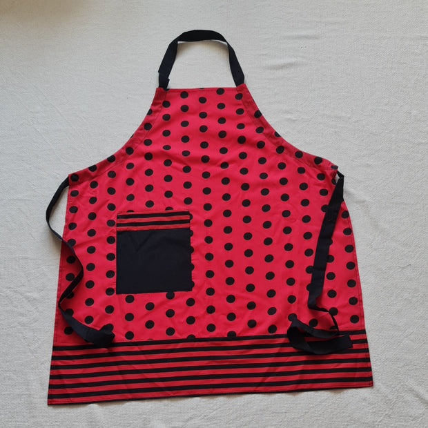 Sarkan melni strīpots un punktots virtuves priekšauts ar krūšu daļu un kabatu sānos