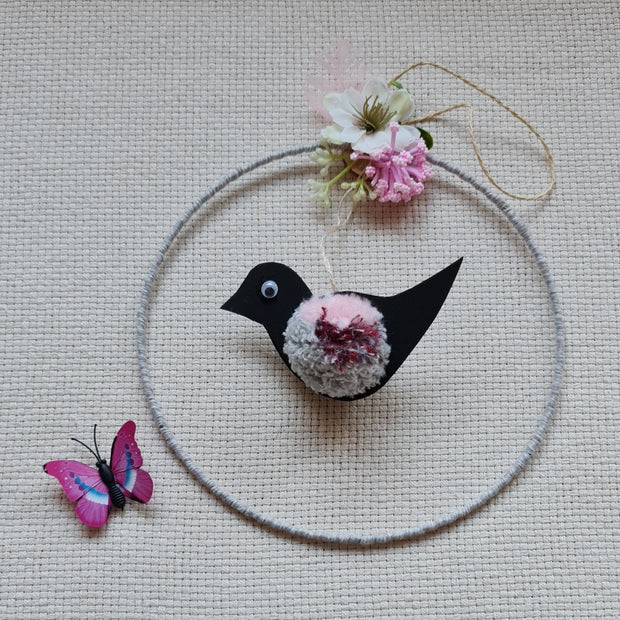 Dekors - magnētisks riņķis ar jebkurā vietā piestiprināmu tauriņu un melnu putniņu kuram ir rozīgi pelēku krāsu dzijas vēderiņš
