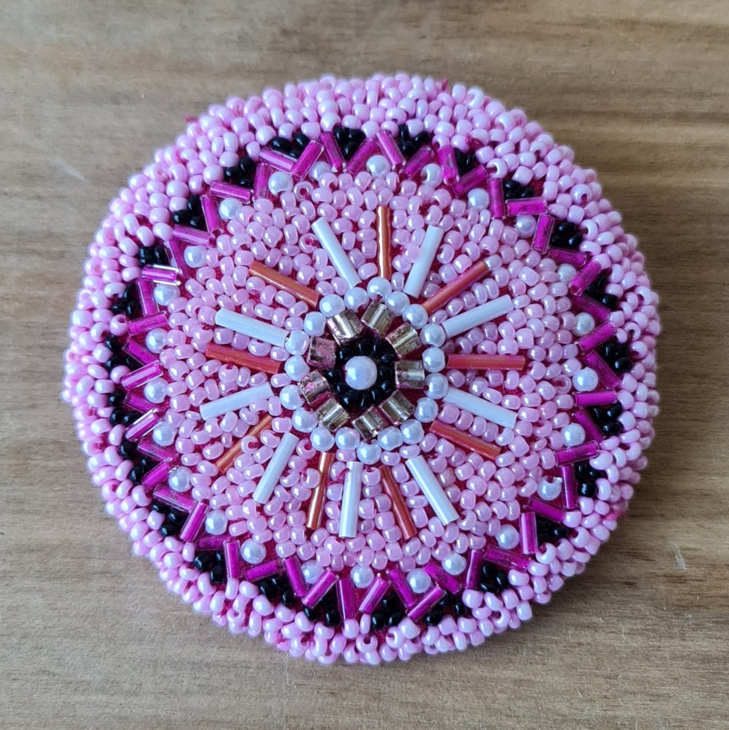 Beaded round brooch in various shades of pink with white and black accents / diameter 7 cm (AMA)