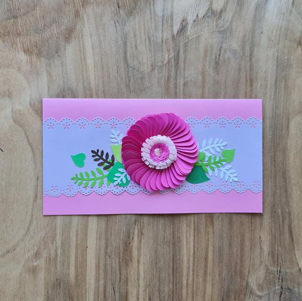 Papīra kartiņa 3D uz gaiši rozā fona tumši rozā zieds ar dekoratīvām zaļām lapām un gaišu joslu ar mežģīņu veida malām 21 x 10.5 cm (AMA)