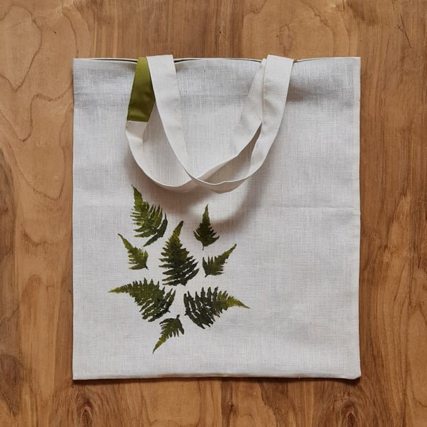 Balts lina auduma iepirkumu maisiņš/soma ar zaļām krāsu aplikācijā veidotām paparžu lapām un baltiem uz pleca liekamiem rokturiem / vienam zaļš akcents (ZMI)
