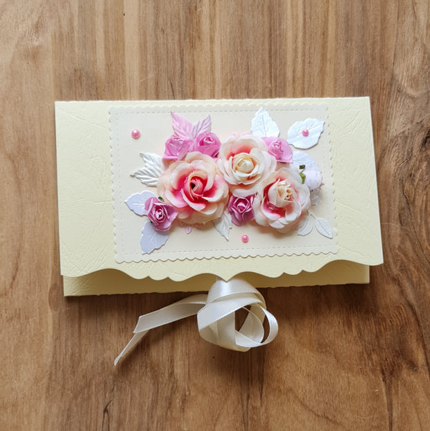 Dāvanu aploksne kremkrāsā ar 3D rozīgi baltiem ziediem un kremkrāsas lentas aizdari 11 x 18 cm (APU2)