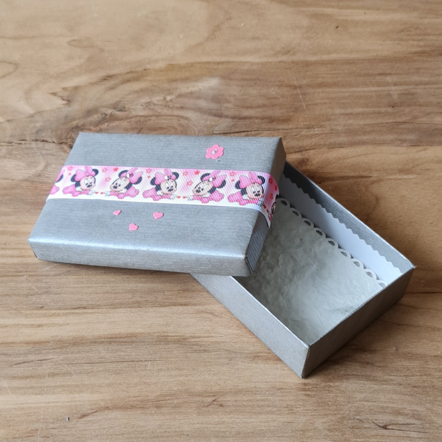 Gift box (inner dimensions 11.8 x 7.8 cm) in silver color with pink mickey mouse ribbon on the lid and light interior (APU2)