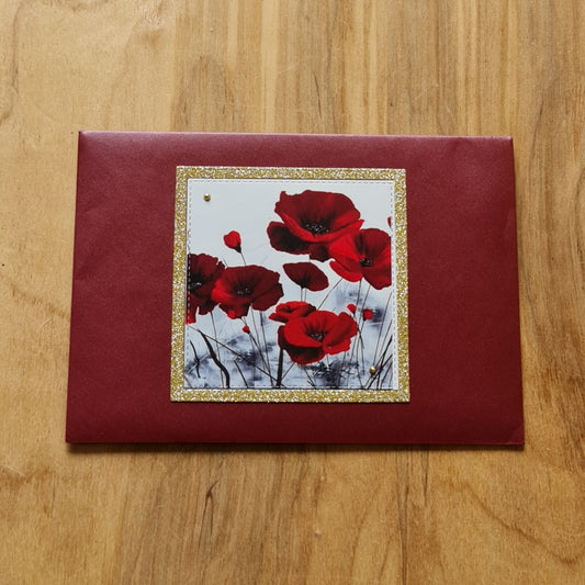 Apsveikuma kartiņa (10.5 x 15 cm) ar sarkani baltu attēlu un aploksne (13.5 x 19.5 cm) ar magoņu ziediem un zeltītu malu (APU2)