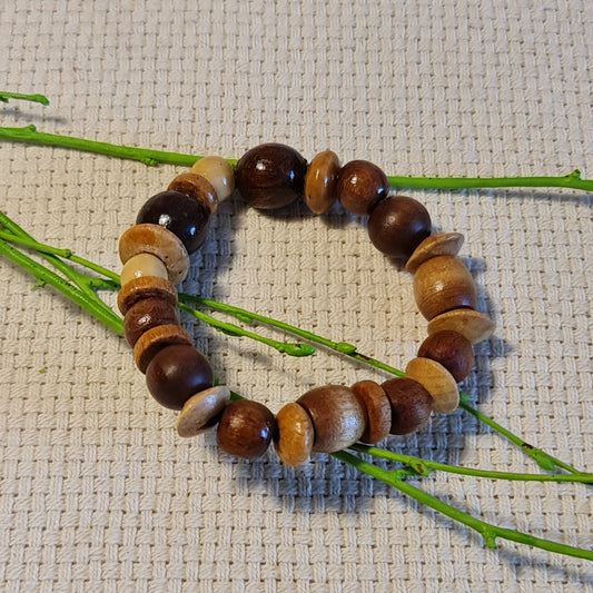 Brown wooden pearl bracelet of different shapes on rubber (diameter 6 cm) (JŠČ)