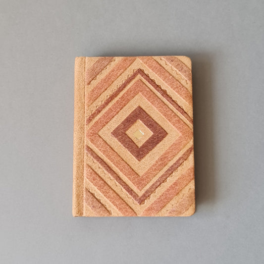 "Poēzijas grāmatiņa" ar vienkrāsainām bēšīgām lapām brūni rozīgā cūkādas ievākojumā ar dekoratīvu rombu iespiedumu. Vidējā - 8.7 x 11.7 x 1.7 cm (MAPL 12)