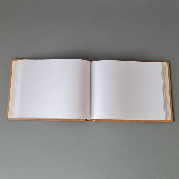 Viesu grāmata ar vienkrāsainām baltām lapām brūnā cūkādas ievākojumā ar dekoratīvu iespiedumu. 19 x 14.5 x 1.7 cm (MAPL)