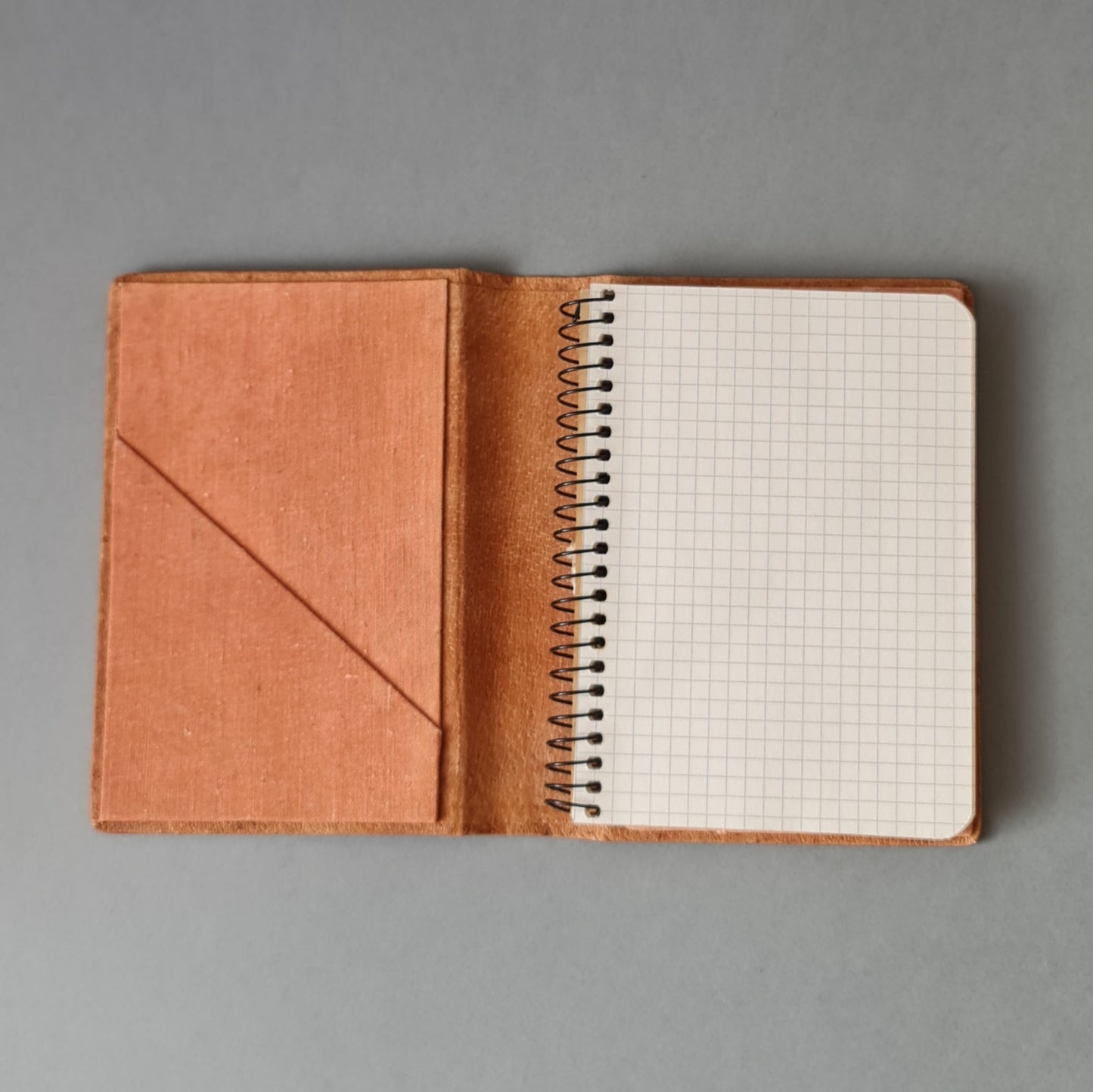 Checked notebook in a leather case with an additional compartment and the possibility to replace the notebook with a spiral. Brown color with decorative print. 11.8 x 15.6 x 1.5 cm (MAPL)