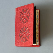 Telefona grāmata ar alfabētu krievu valodā ādas ievākojumā. Tumši sarkanā krāsā ar dekoratīvu iespiedumu. Mini 5.8 x 8.9 x 0.9 cm (MAPL)