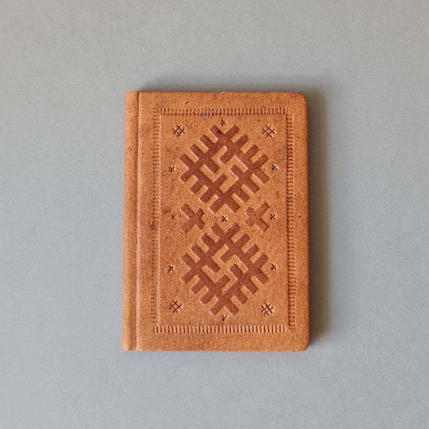 Telefona grāmata ar alfabētu latviešu valodā ādas ievākojumā. Brūnā krāsā ar dekoratīvu iespiedumu. Maza 8 x 11 x 0.9 cm (MAPL)