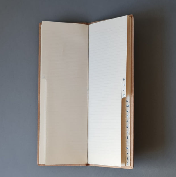 Telefona grāmata ar alfabētu latviešu valodā ādas ievākojumā. Gaiši brūnā krāsā ar dekoratīvu iespiedumu. Garena 10.5 x 30 x 0.9 cm (MAPL)
