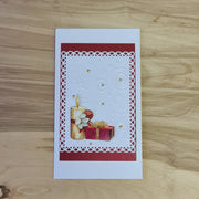 Ziemassvētku dāvanu aploksne/kartiņa 3D. Balti sudrabaina ar sarkanu rāmīti / sveci un dāvanu / iekšpusē balti elementi. 10 x 17.6 cm (AIPU 46)