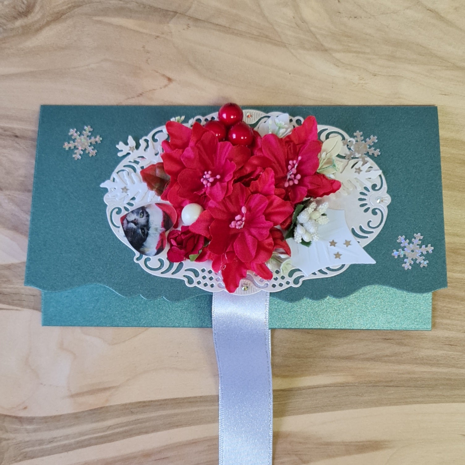 Dāvanu aploksne/kartiņa perlamutra zaļā krāsā ar 3D sarkaniem un kremkrāsas ziediem uz gaiša fona / plata sudrabotas lentas aizdare / iekšpusē balti sudrabota vēlējuma daļa 10.8 x 19 cm (AIPU) - www.tiptip.lv 