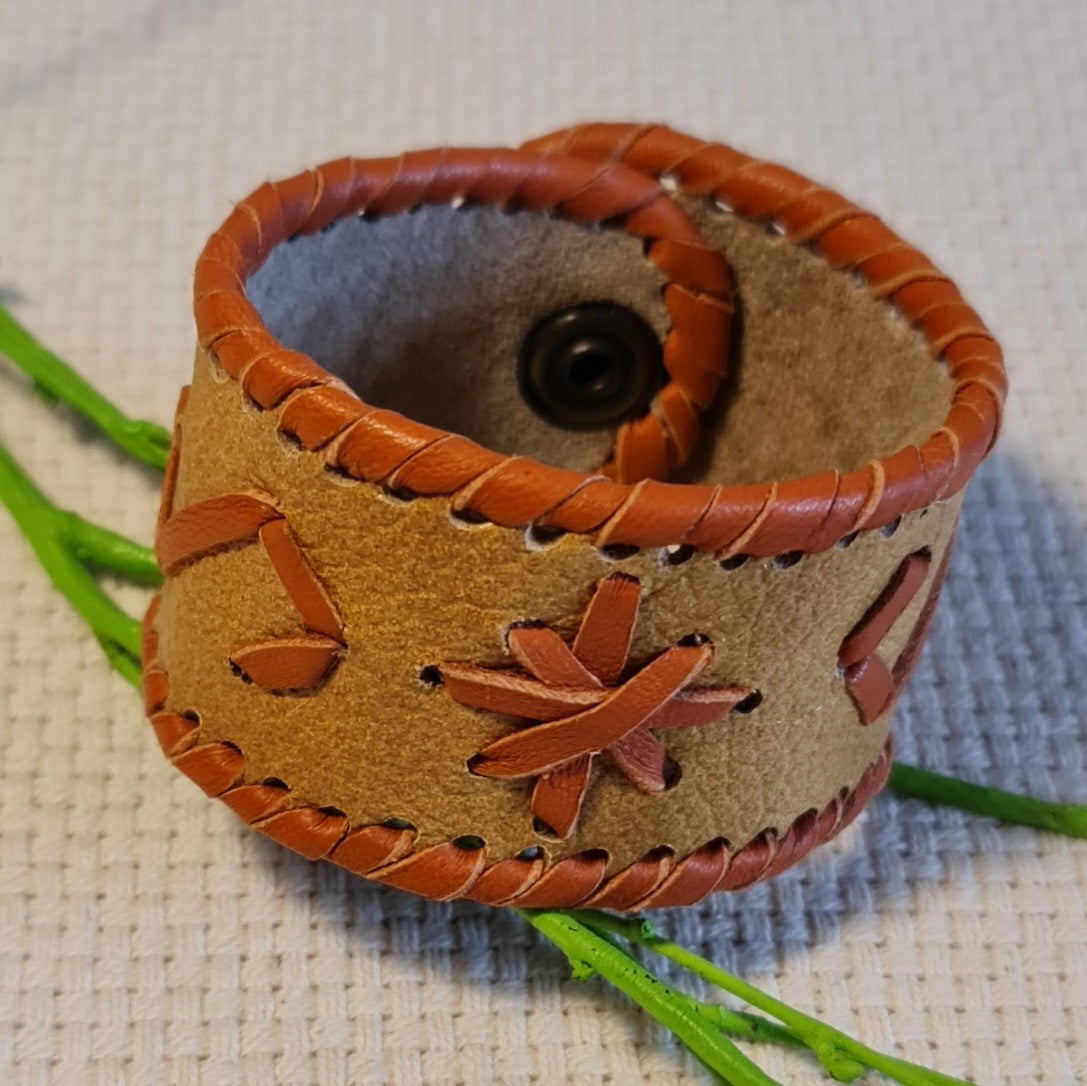 Joslas formas gaiši brūna ādas rokassprādze ar oranžīgiem šūtiem dekoratīviem elementiem un spiedpogas aizdari (JŠČ) - www.tiptip.lv 