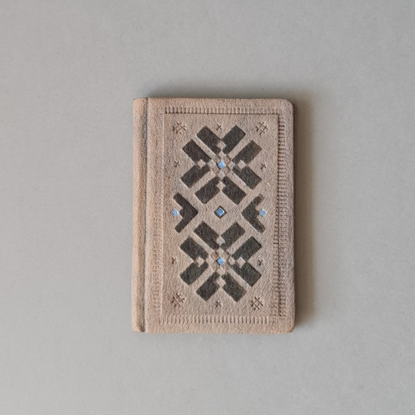 Rūtiņu bloknots ādas ievākojumā. Zilpelēkā krāsā ar dekoratīvu iespiedumu. 7 x 10 x 1 cm (MAPL 3) - www.tiptip.lv 