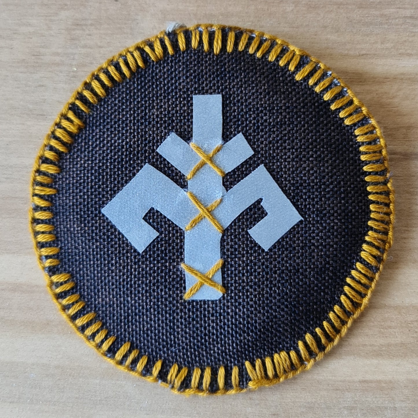 Šūts apaļš dekors ar atstarojošu Austras koku vienā pusē un Ūsiņa zīmi otrā un mīkstu tumši brūnu pamatni / diametrs 7.5 cm (AMA) - www.tiptip.lv 